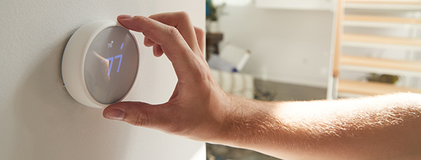 person using a smart thermostat